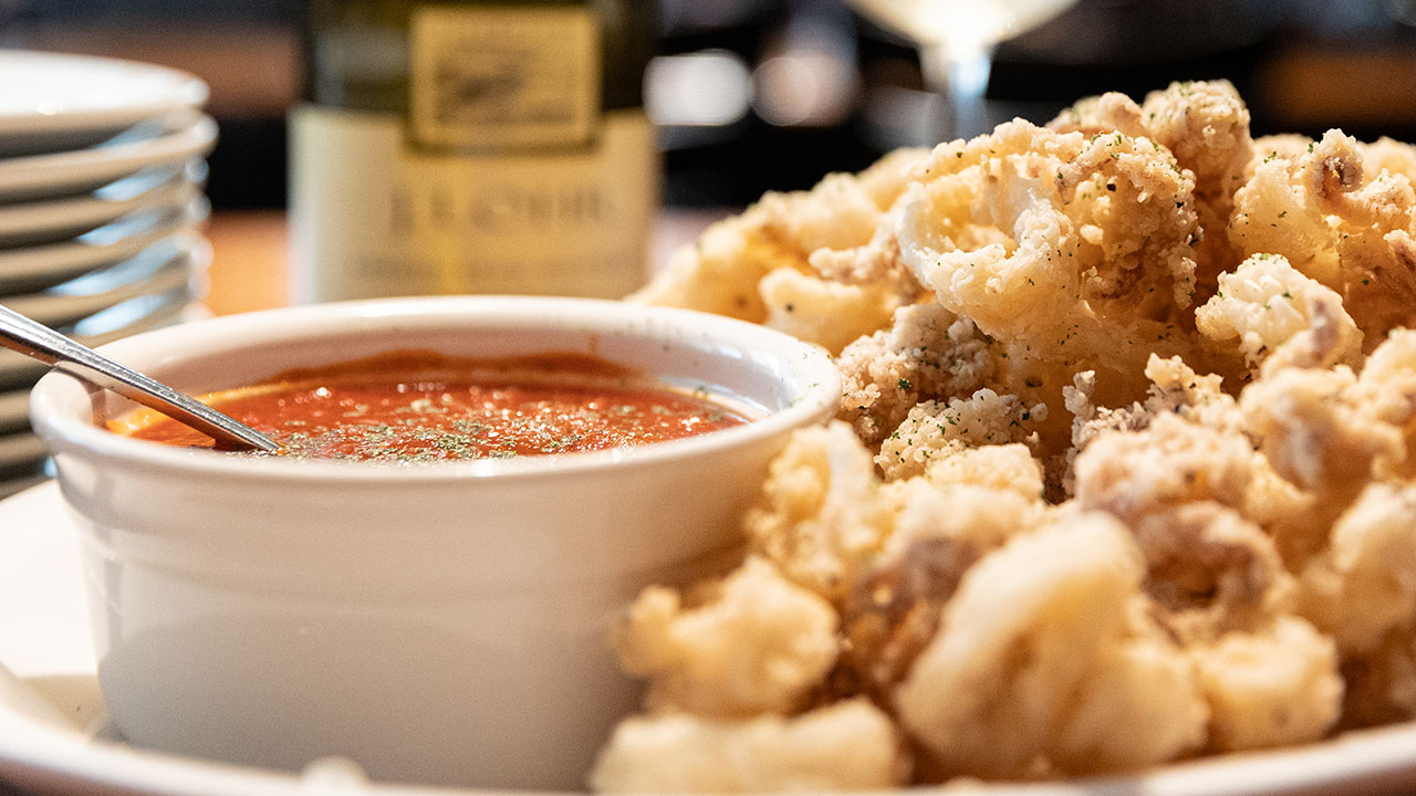 photo the fried calamari on a plate with a bowl of dipping sauce